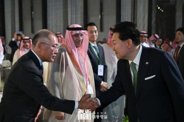 现代汽车集团董事长郑义宣在2023年10月22日利雅得举行的韩国企业与沙特合作伙伴投资论坛上与韩国总统尹在寅握手。（图片来源：韩国总统府）